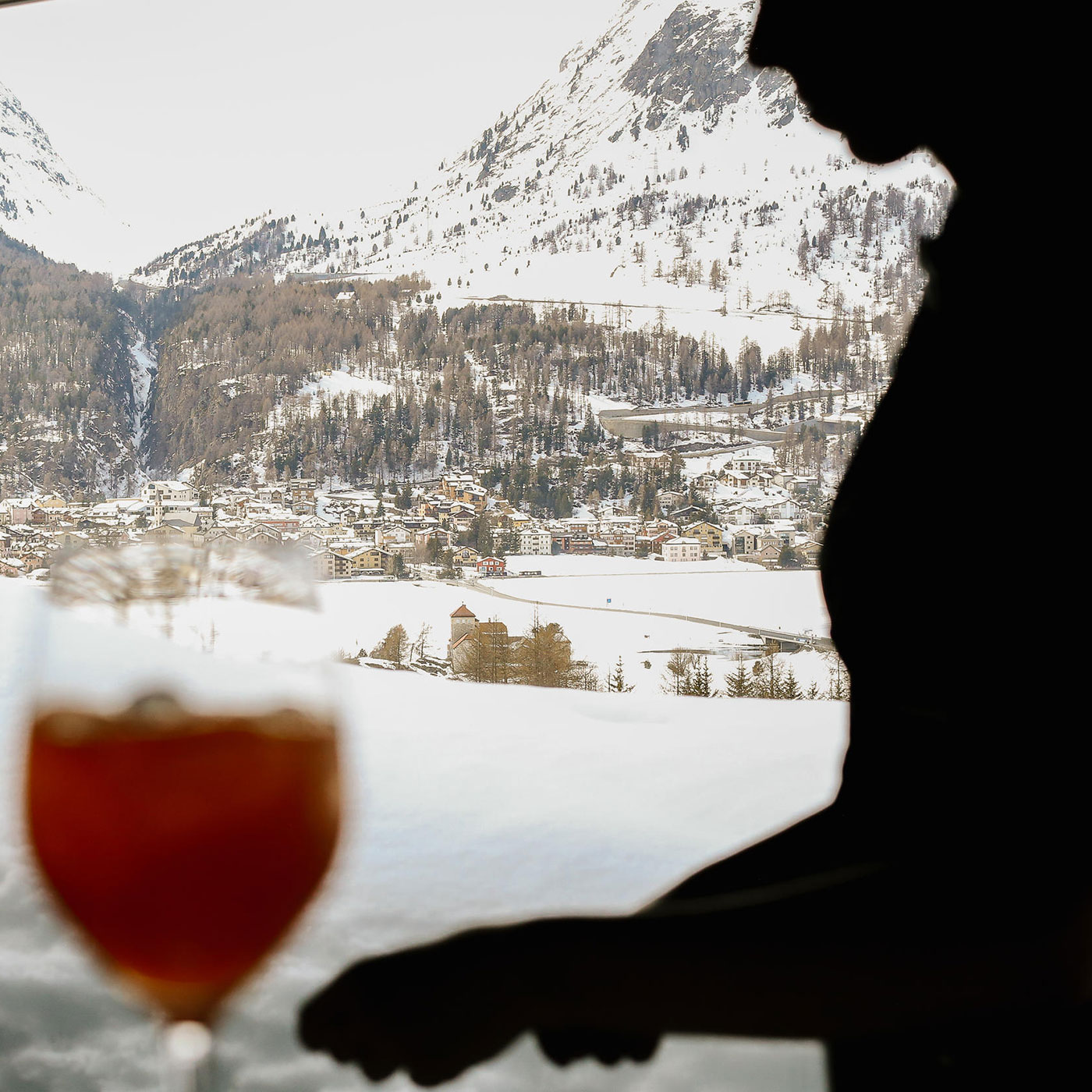 Frau serviert Drink vor Bergkulisse