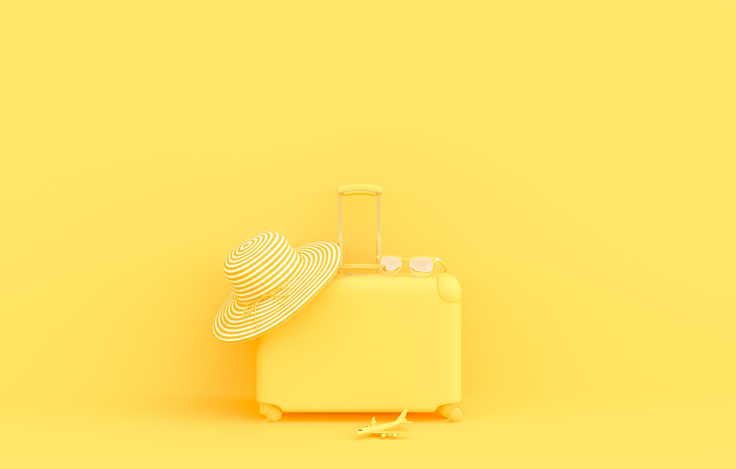 Gelber Koffer mit Sonnenhut und Brille