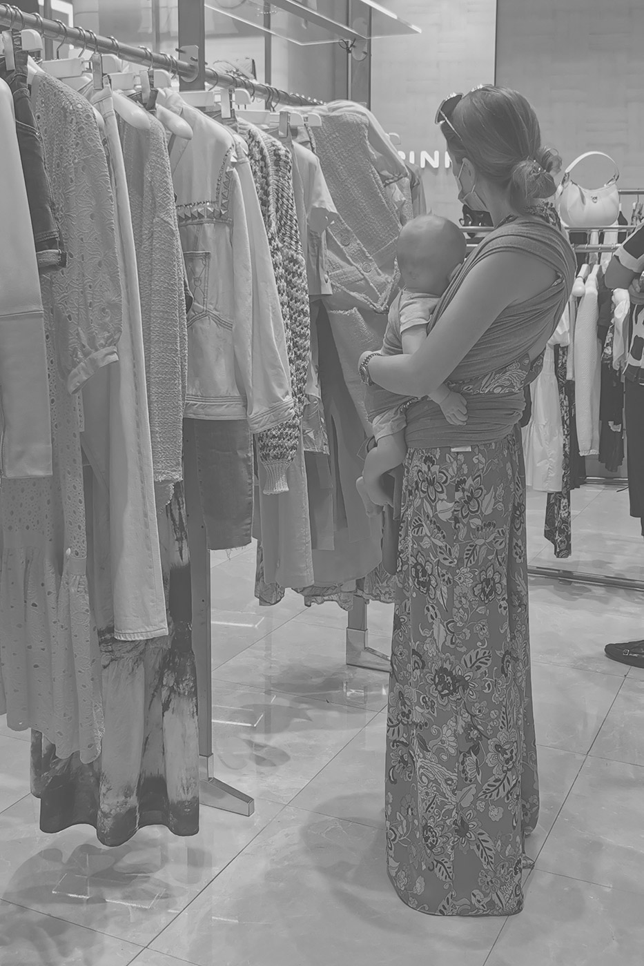 Frau mit Baby am Arm beim Shoppen