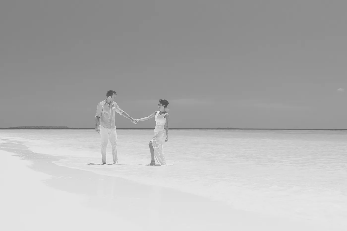 Verliebtes Paar geht händchenhaltend am Strand