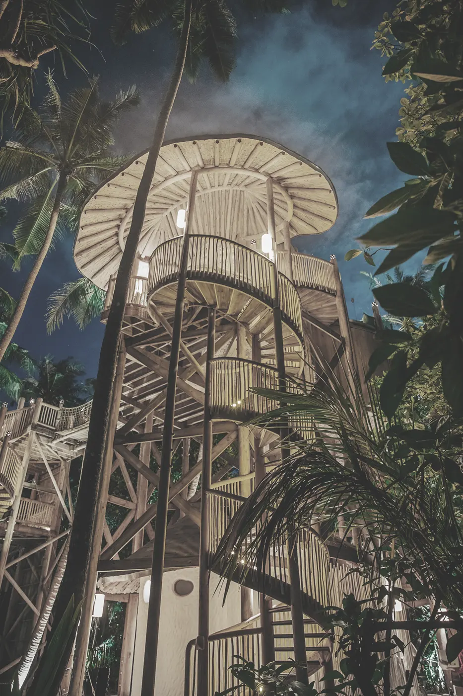 Baumhaus mit Wendeltreppe zwischen Palmen