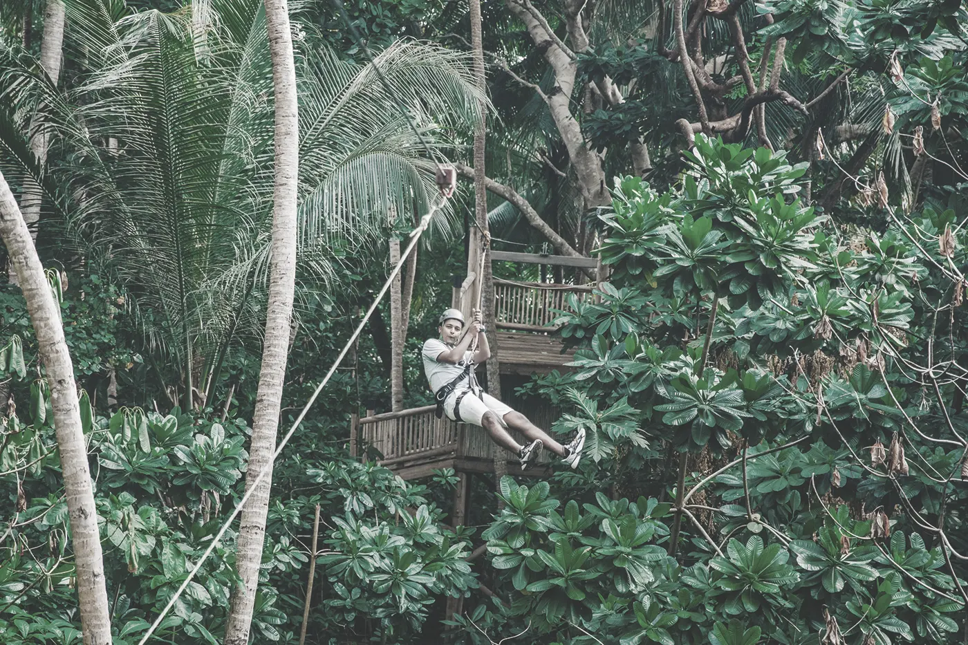 Mann hängt an einer Zipline im Dschungel