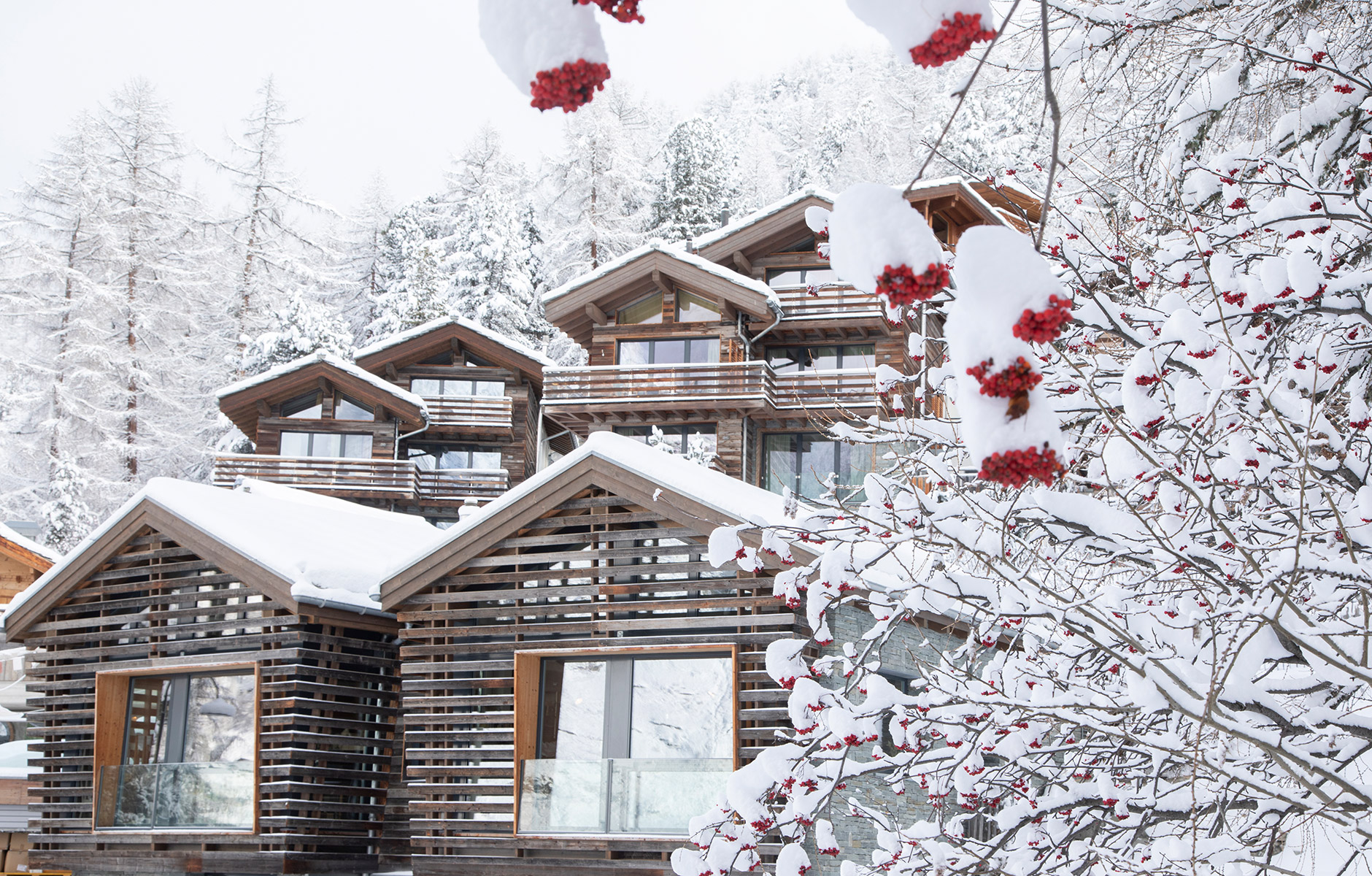 Holzhäuser des Hotels an winterlichem Berghang