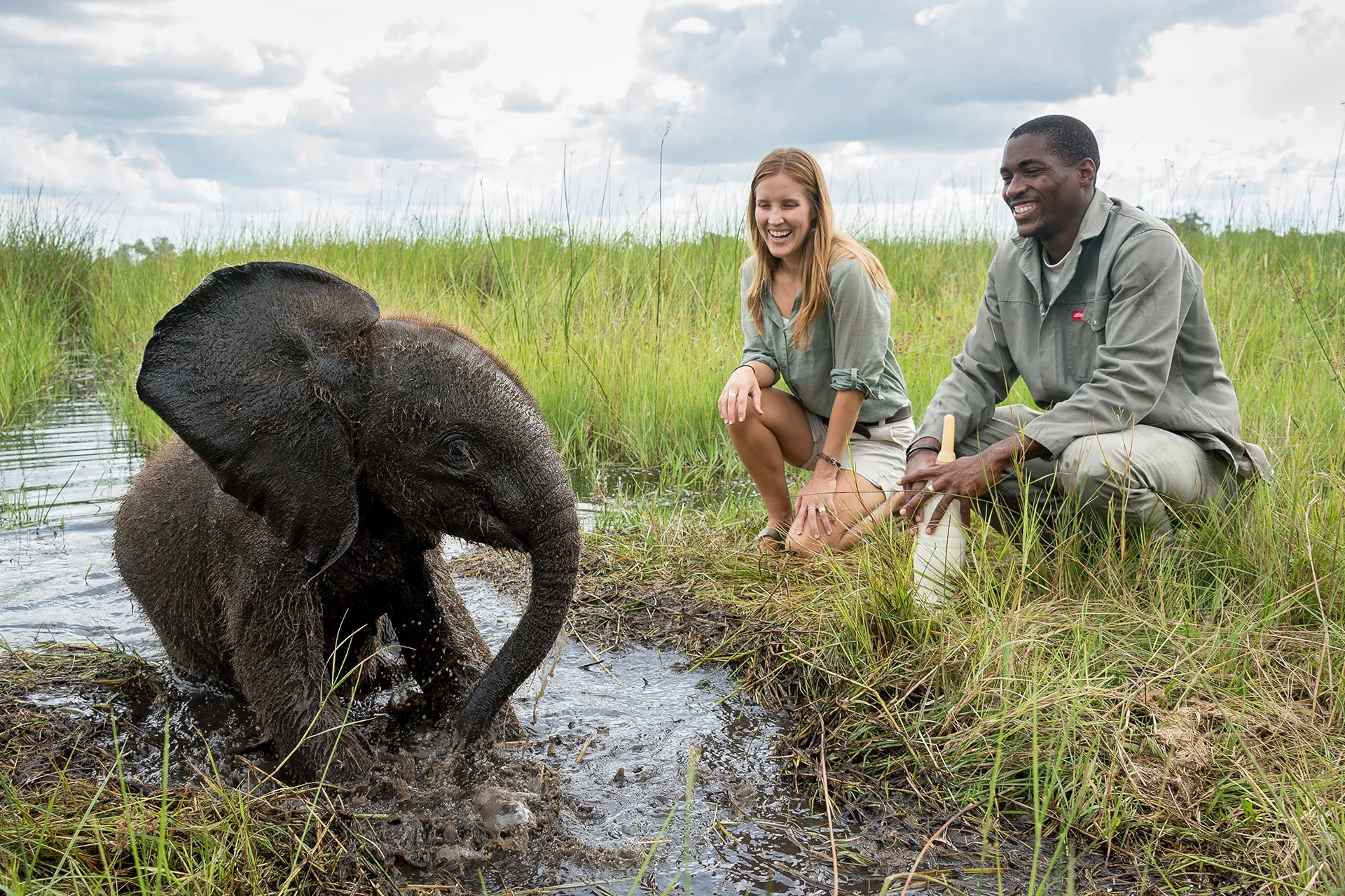 Zwei Personen vor Elefantenbaby