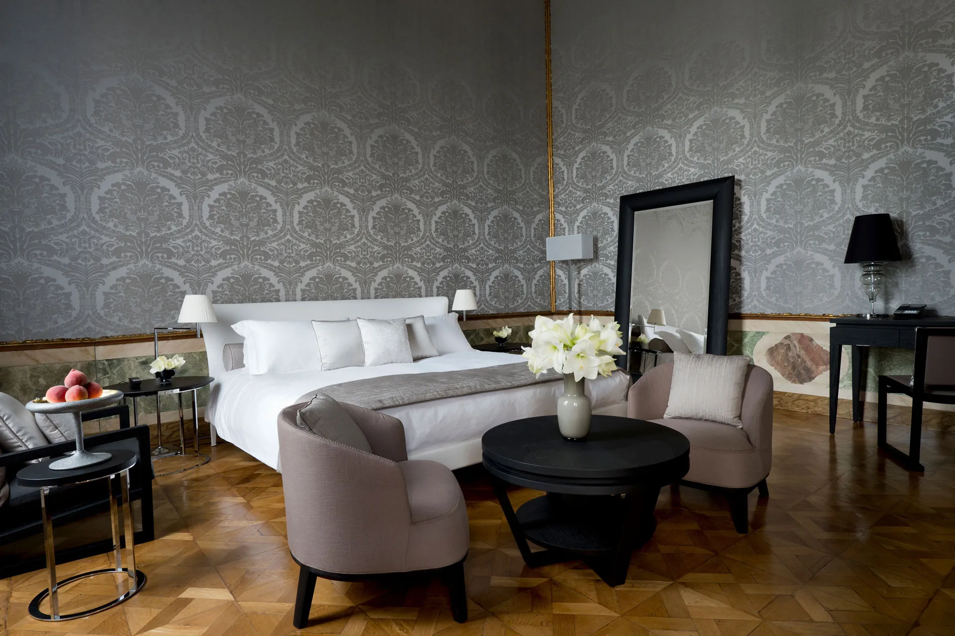 Doppelbett vor grau tapezierter Wand mit Muster