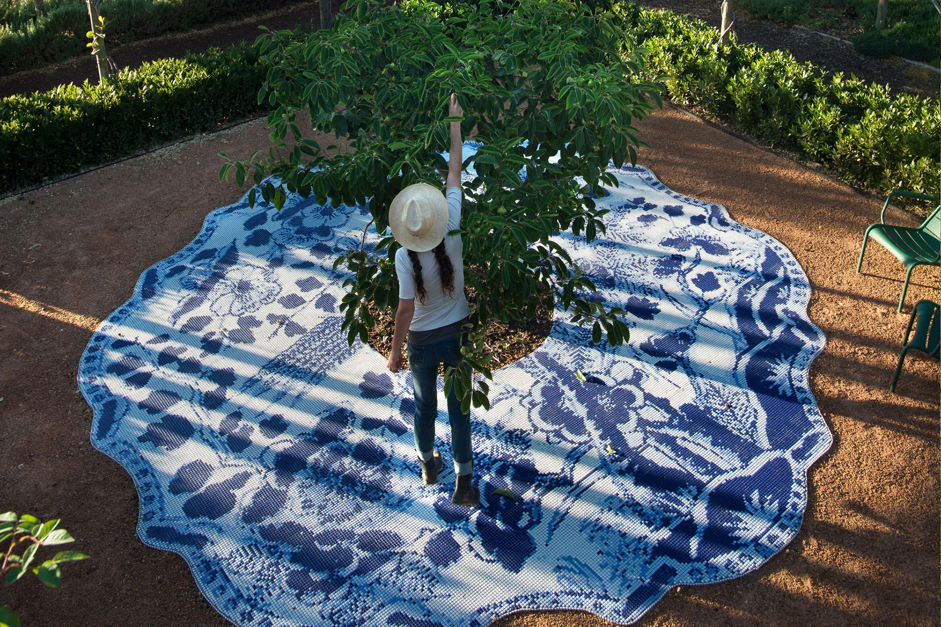 Frau steht auf Mosaicboden unter Baum