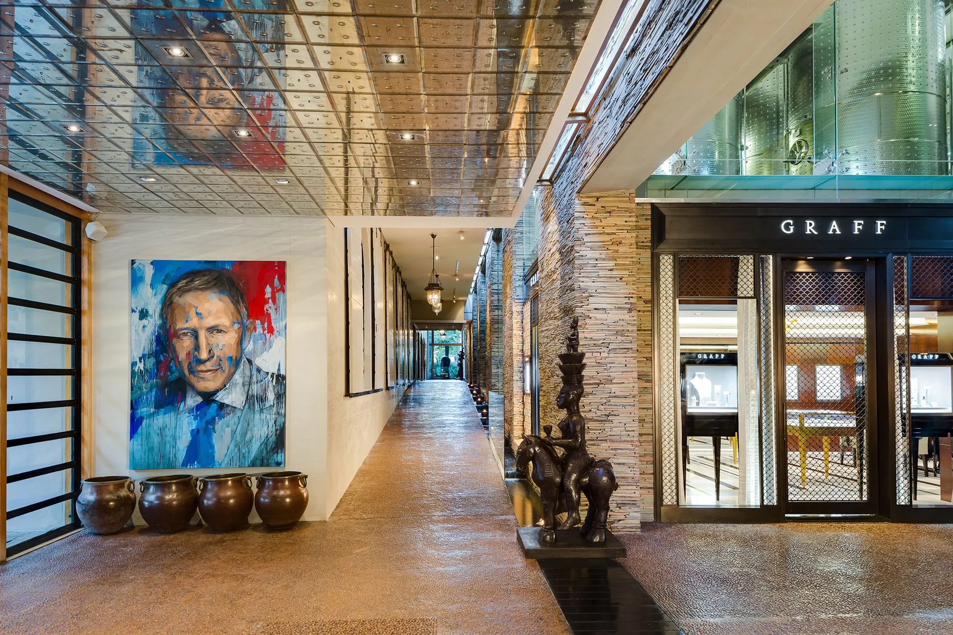 Langer Corridor mit Steinwand und Kunstobjekten