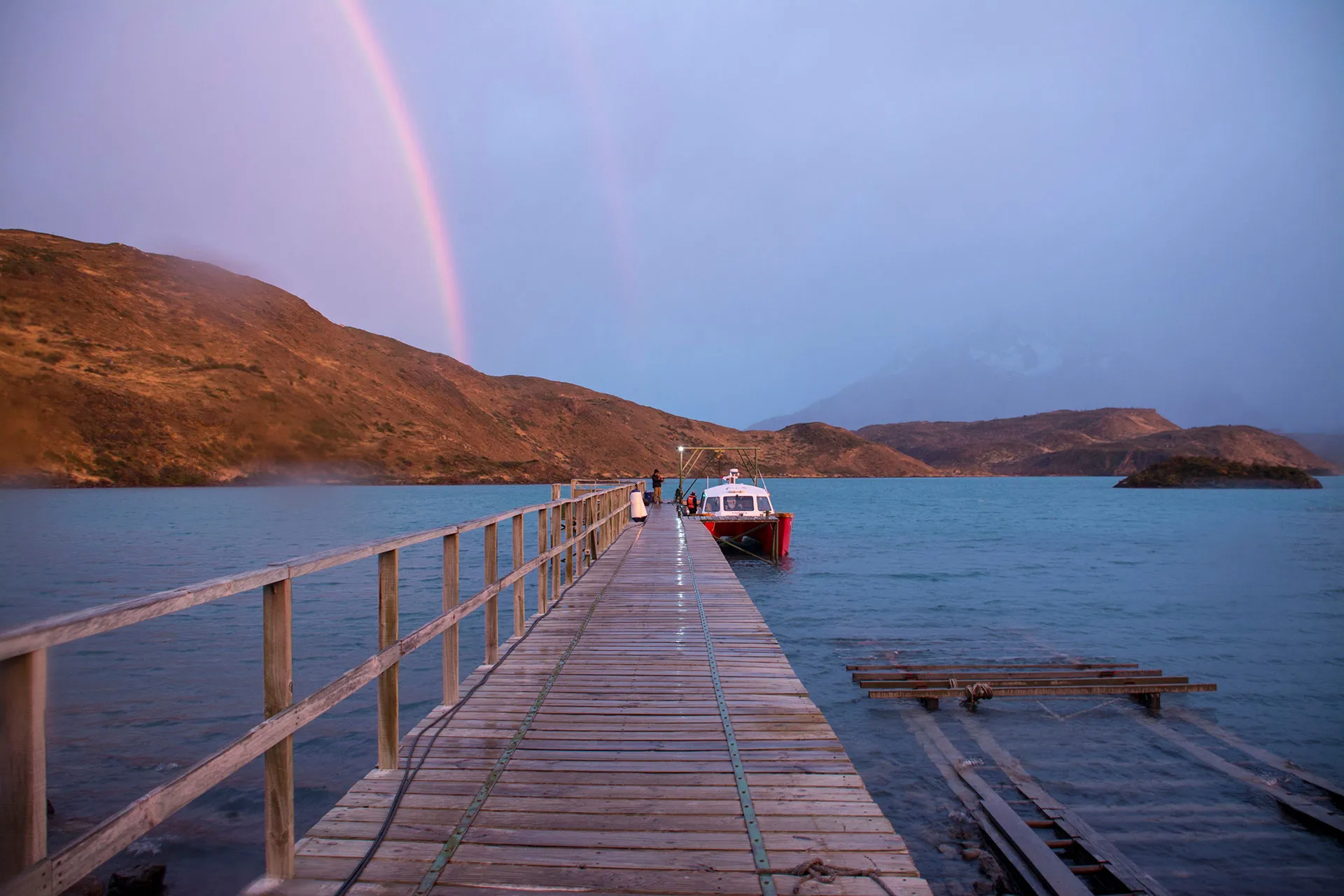 Regenbogen über Holzsteg mit Boot