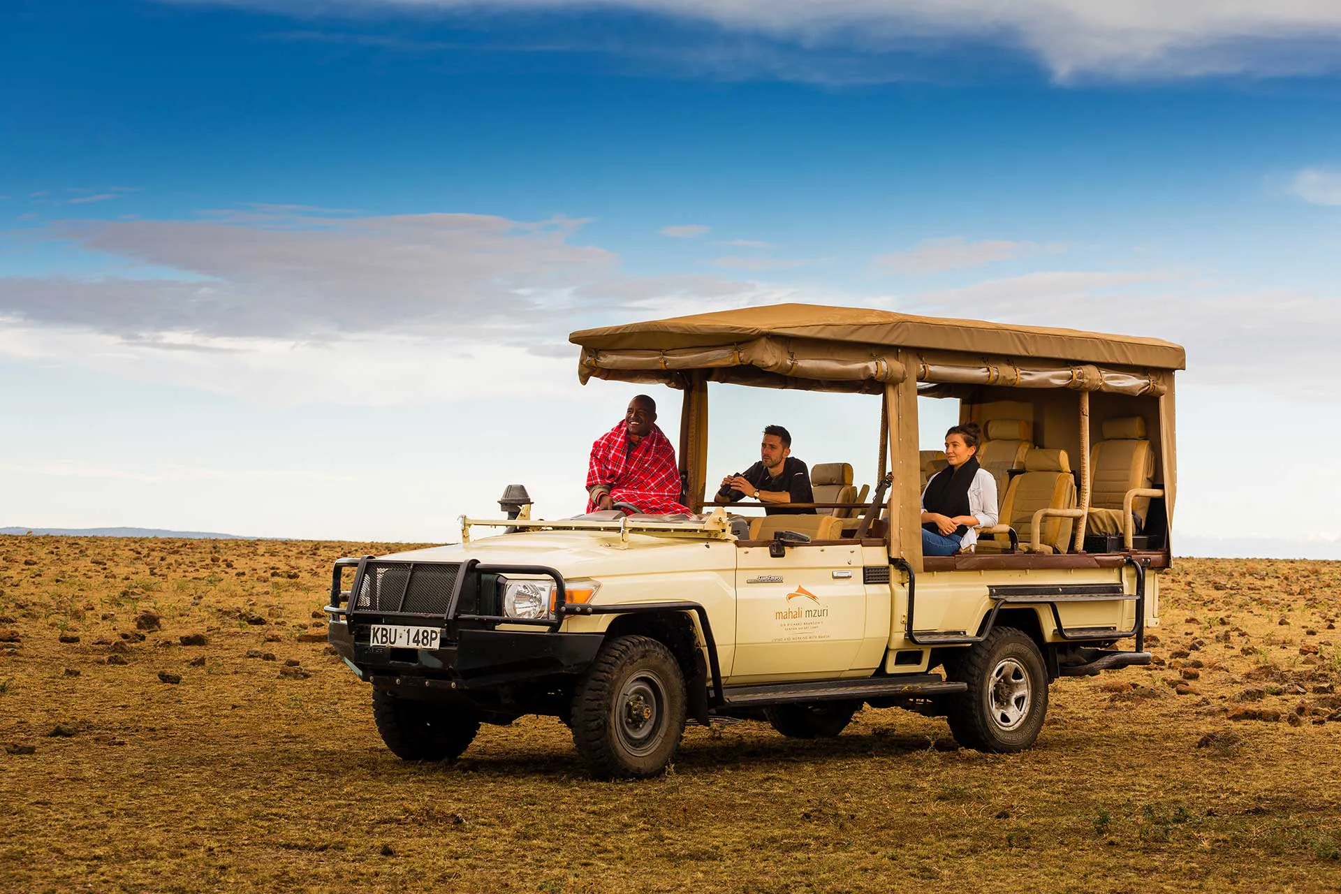 Drei Personen auf Safari Jeep