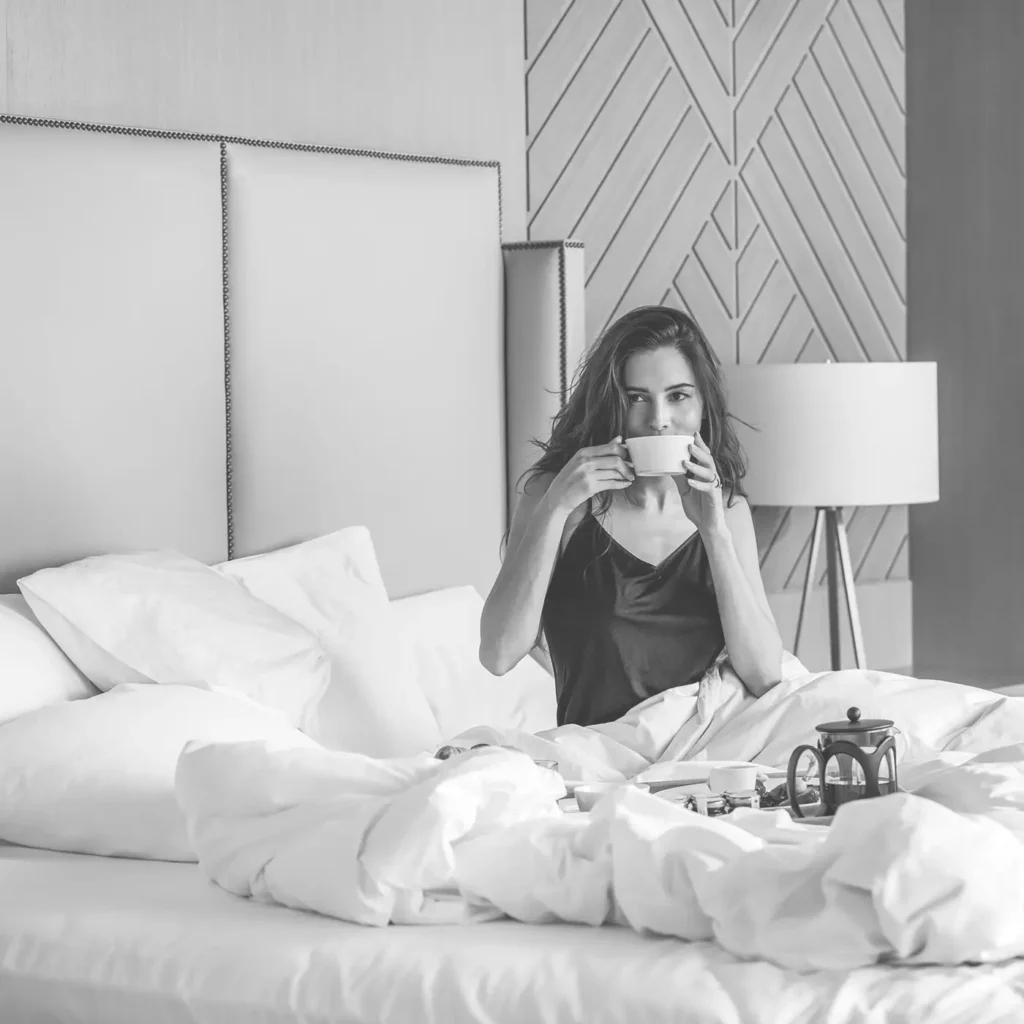 Frau trinkt Kaffee im Bett