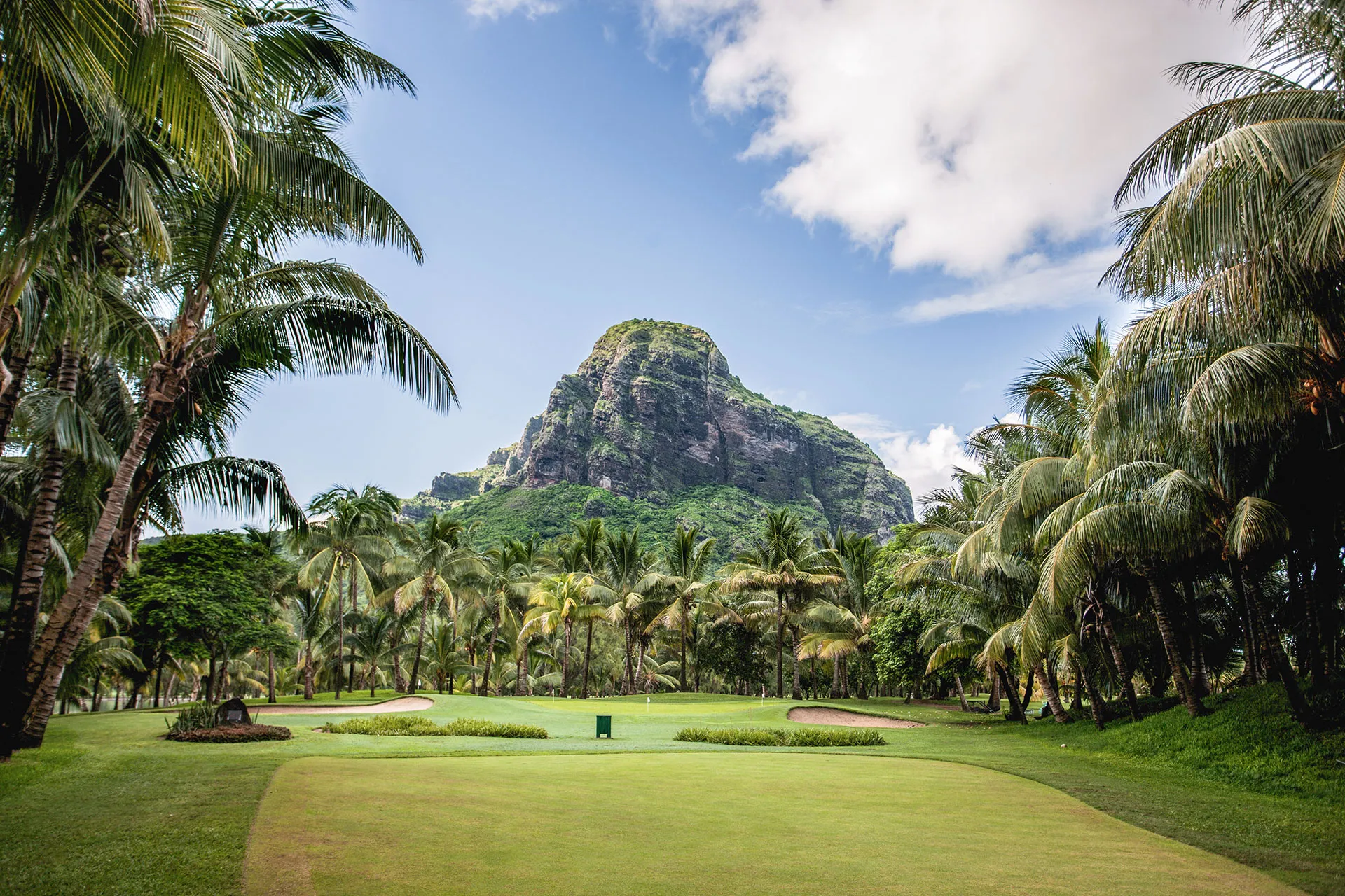 Golfplatz unter Palmen und Bergkulisse