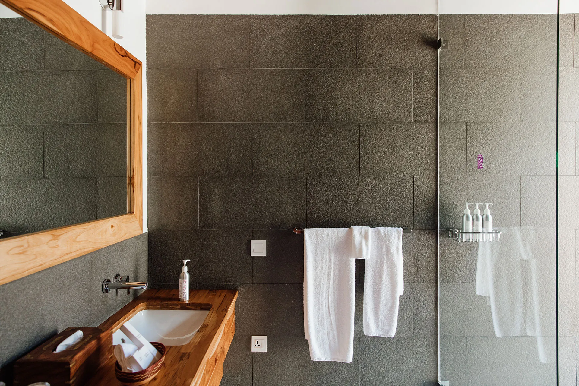 Badezimmer mit Steinwand und Holzflächen