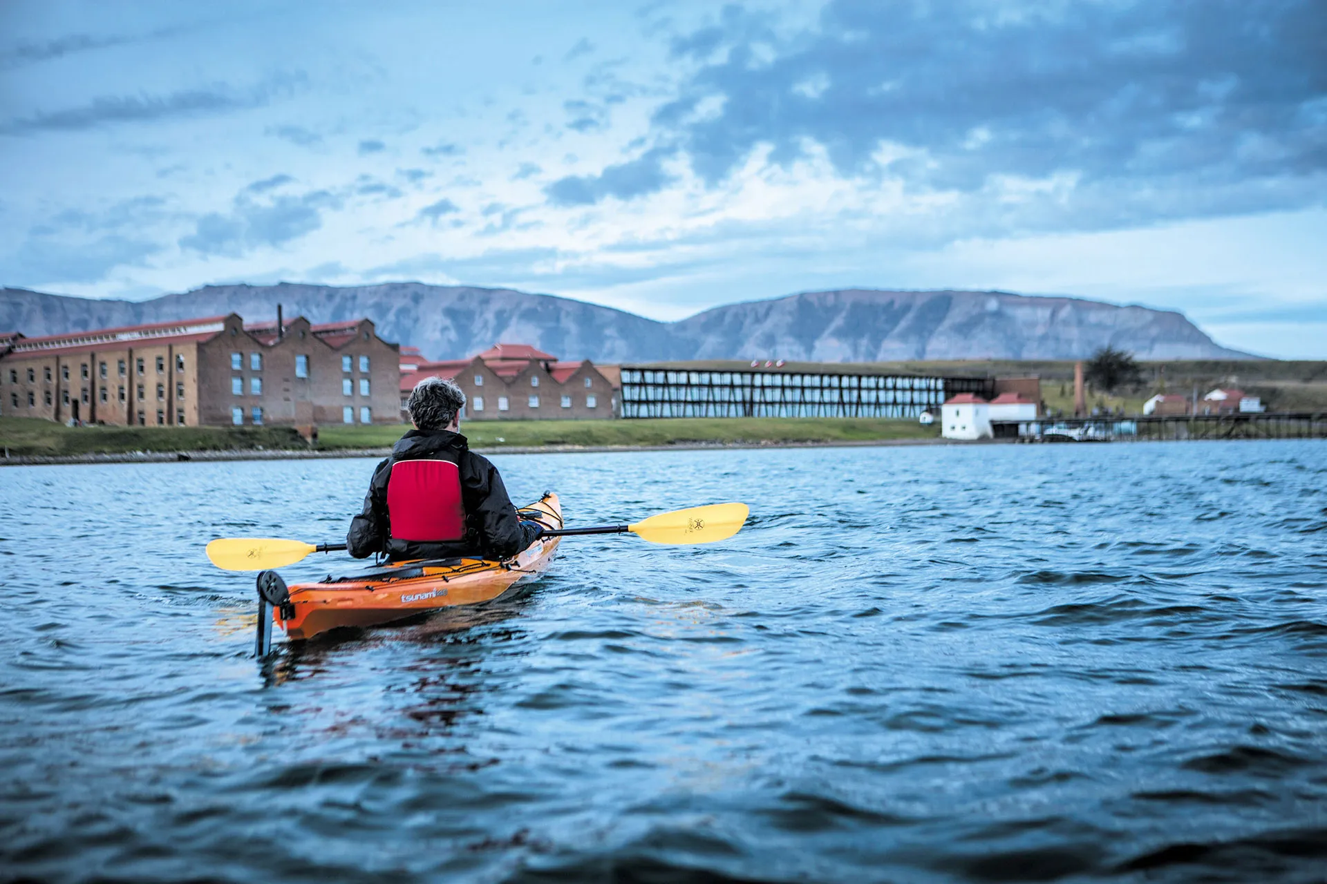 Kayakfahrer vor Küste mit Gebäude