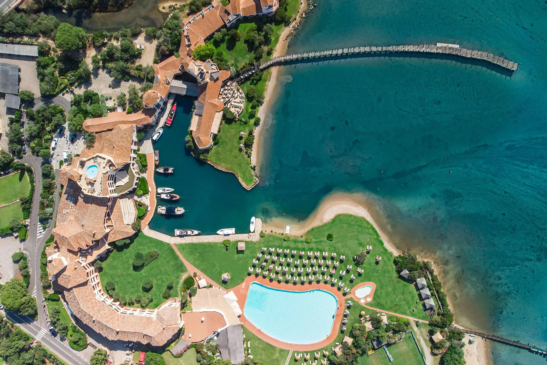 Luftaufnahme einer Hotelanlage mit Gärten und Strand