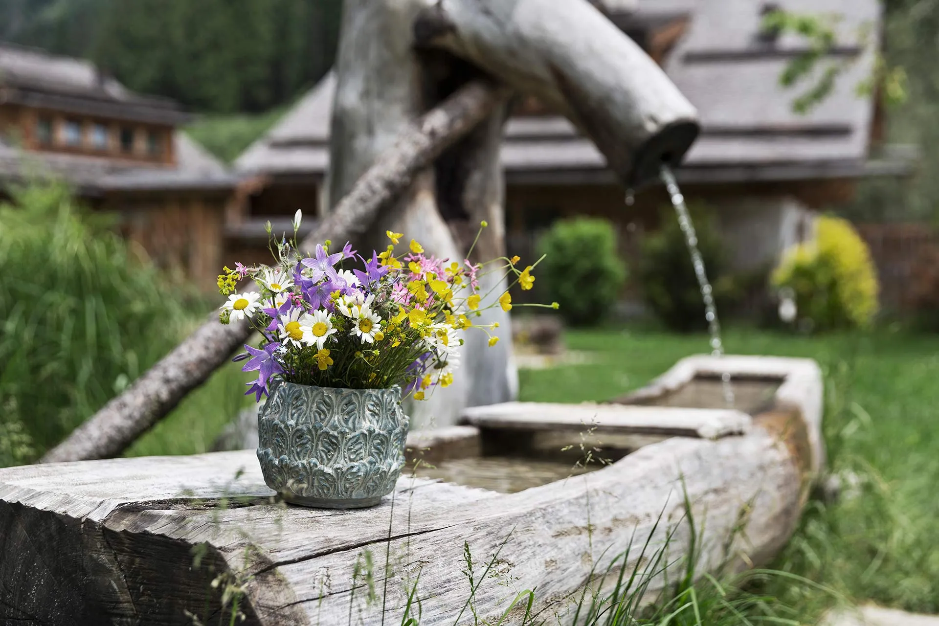 Blumenstrauss auf einem Holzbrunnen