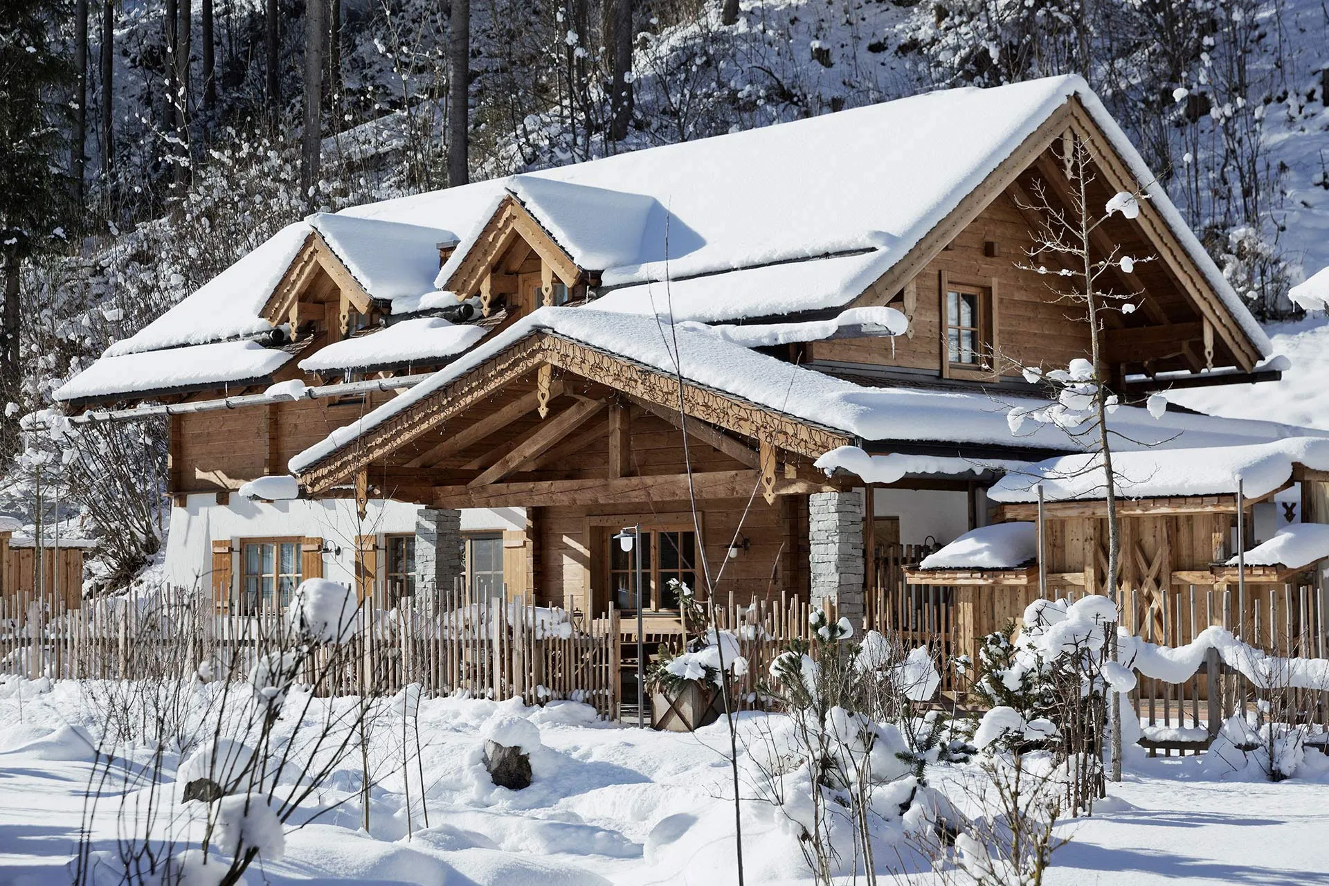 Eingeschneites Holzhaus in Winterlandschaft