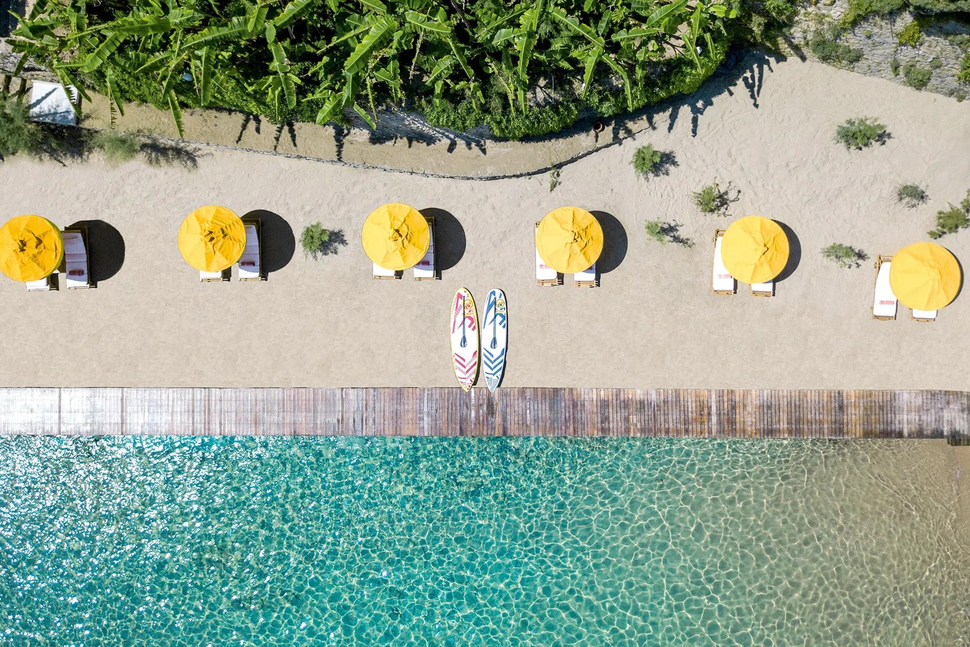 Luftaufnahme eines Strandstreifens mit Sonnenschirme