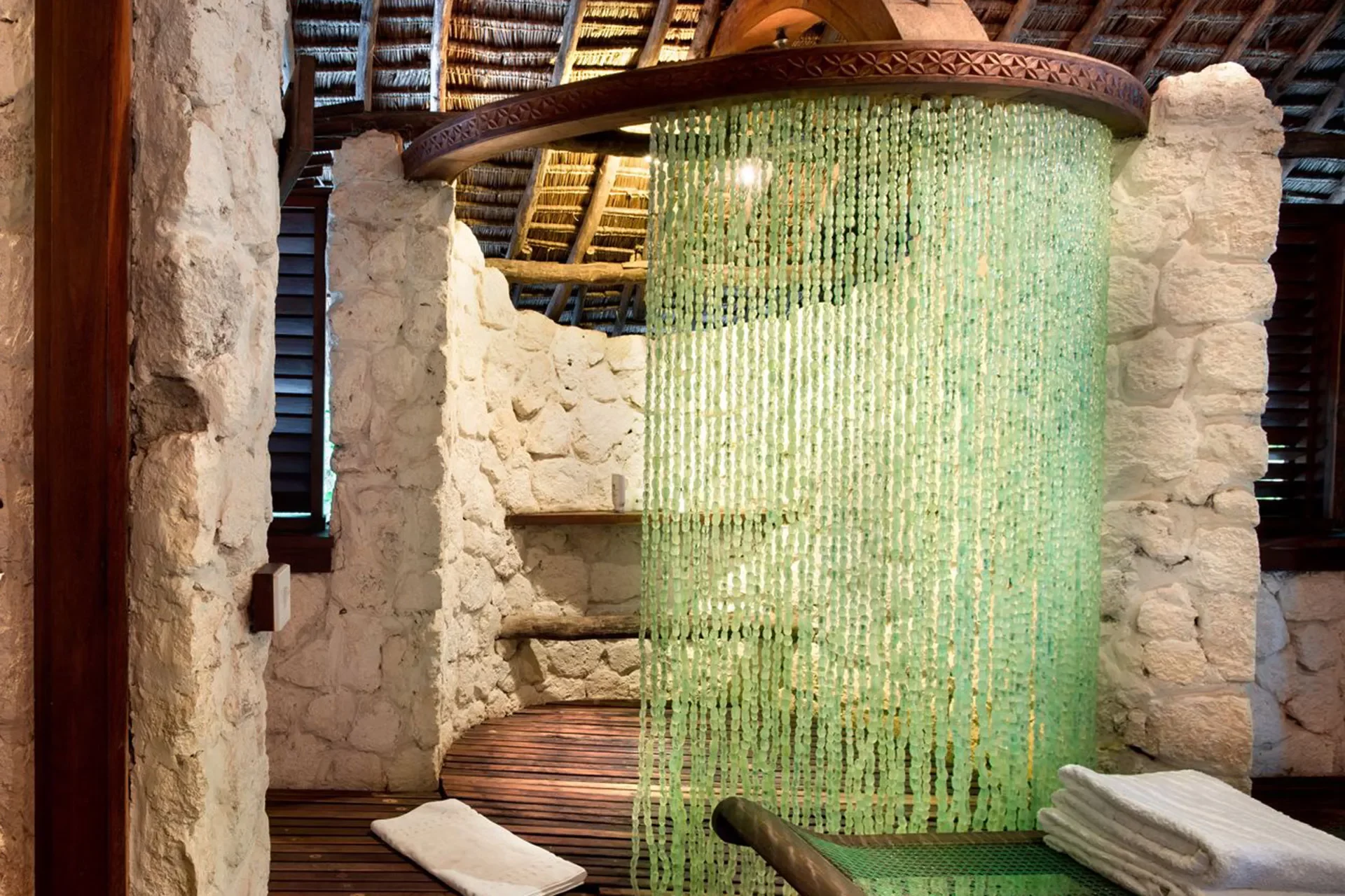 Steinerne Dusche mit Vorhang aus Glasperlen