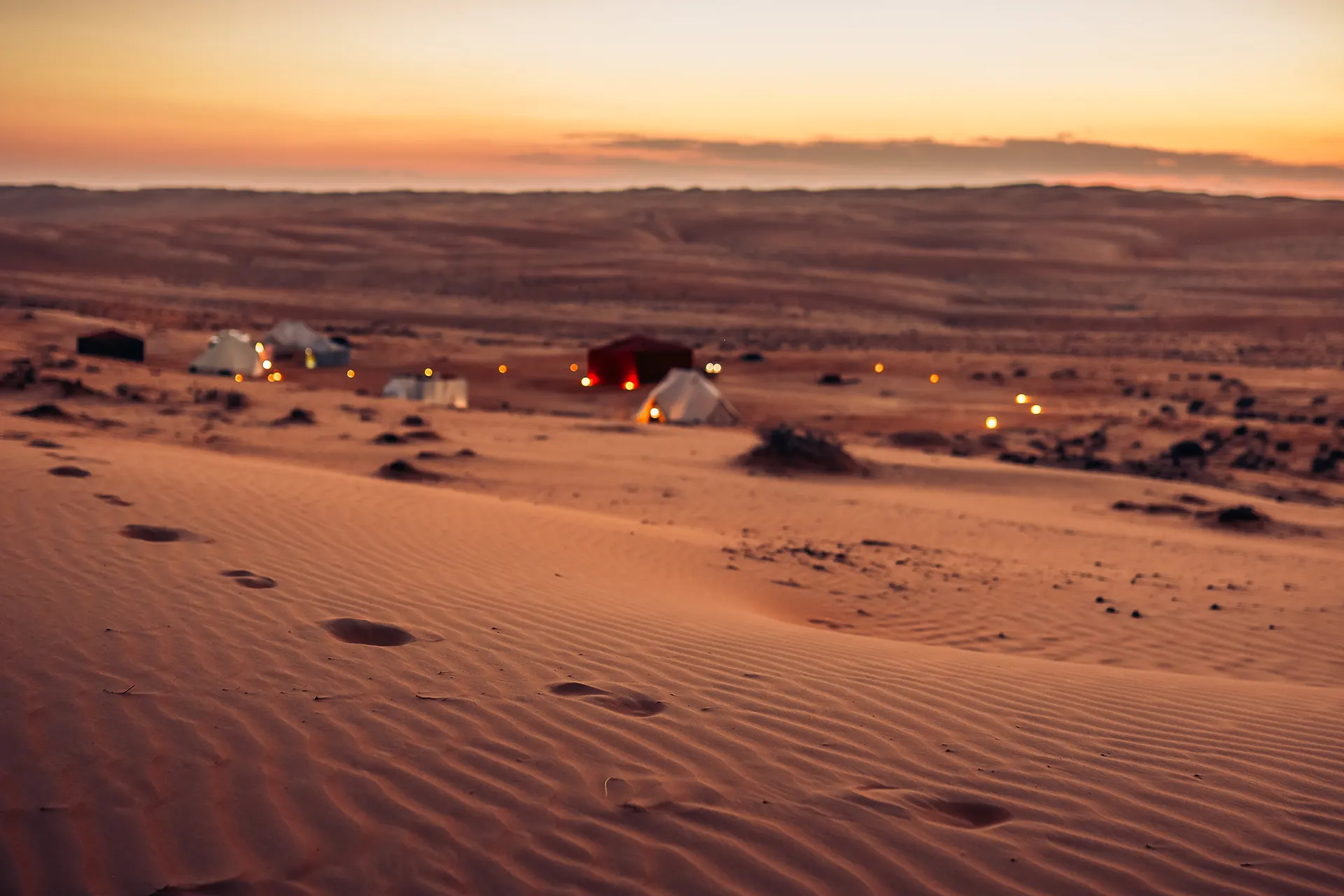 Blick von einer Sanddüne auf mehrere Zelte