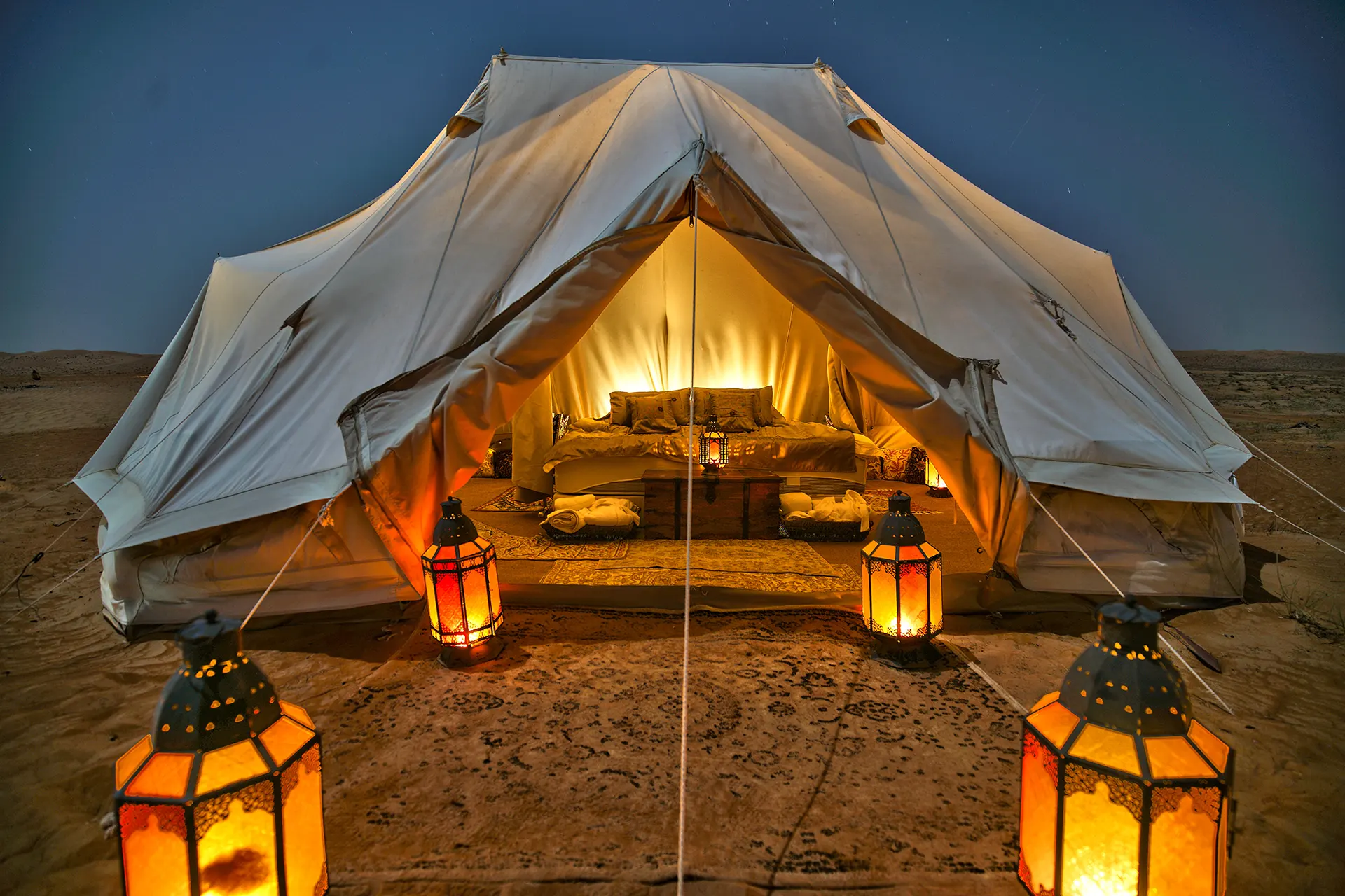 Blick in ein beleuchtetes Zelt mit Doppelbett