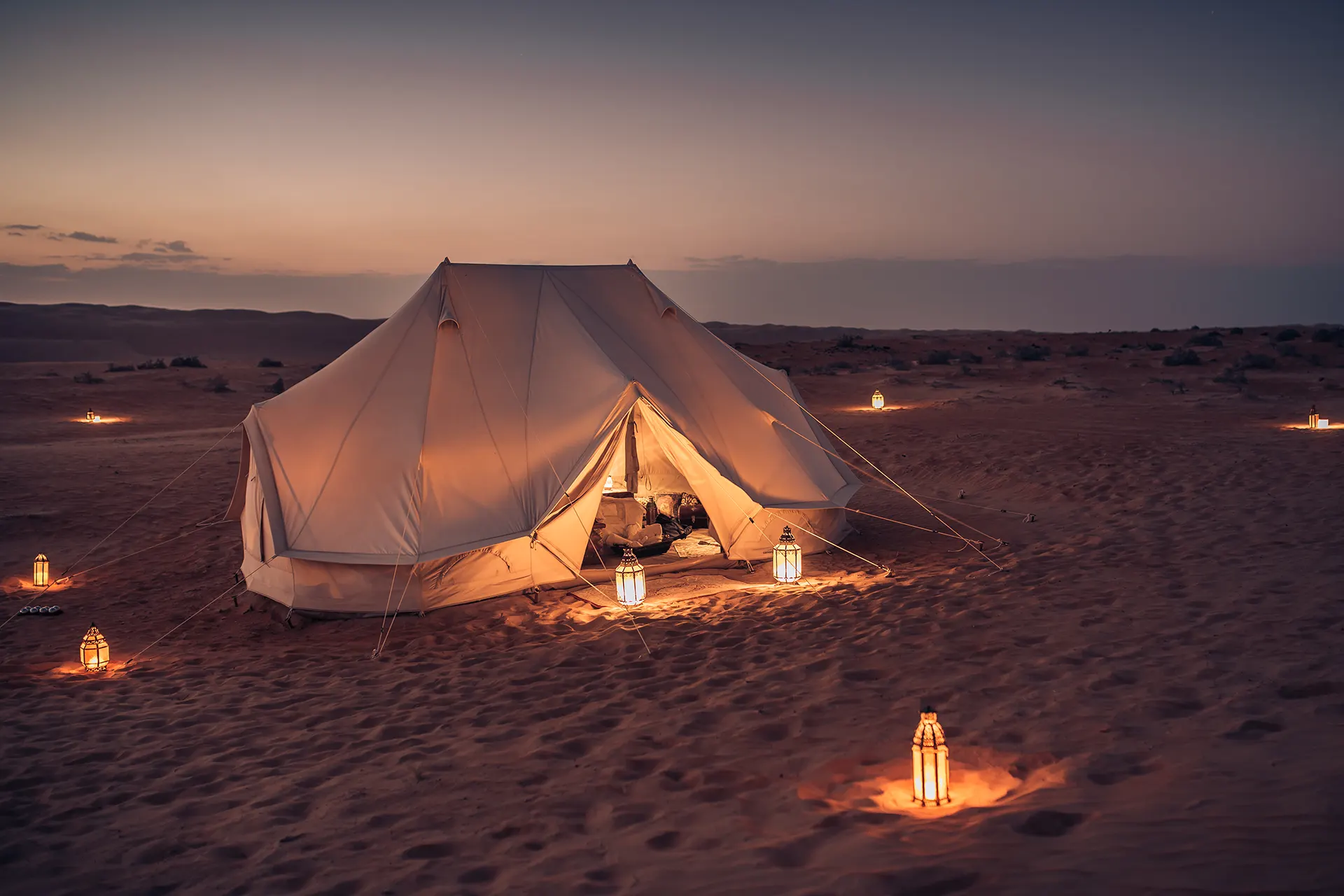 Weißes Zelt mit Laternen in der Wüste
