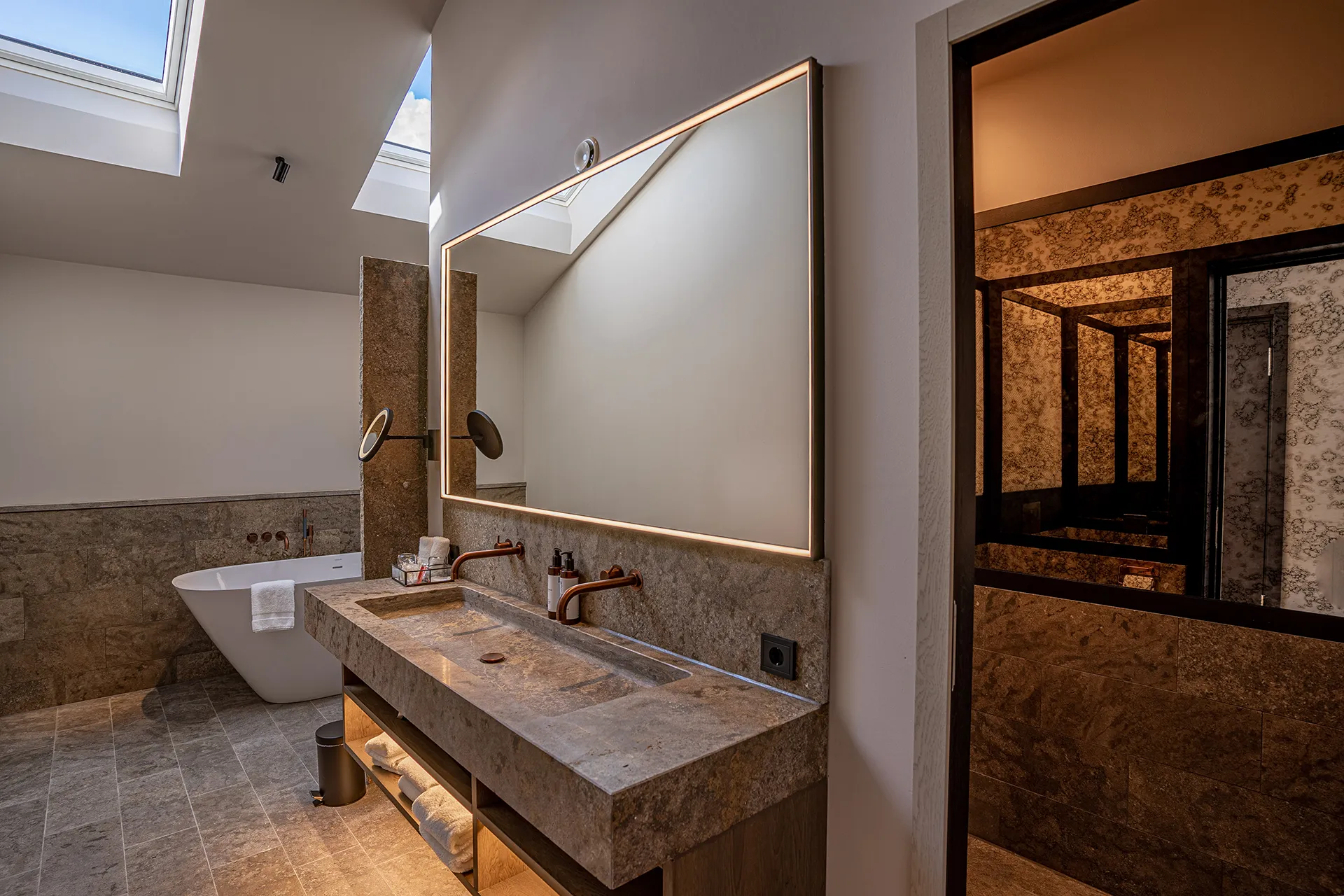 Badezimmer mit Waschbecken und Boden aus Stein