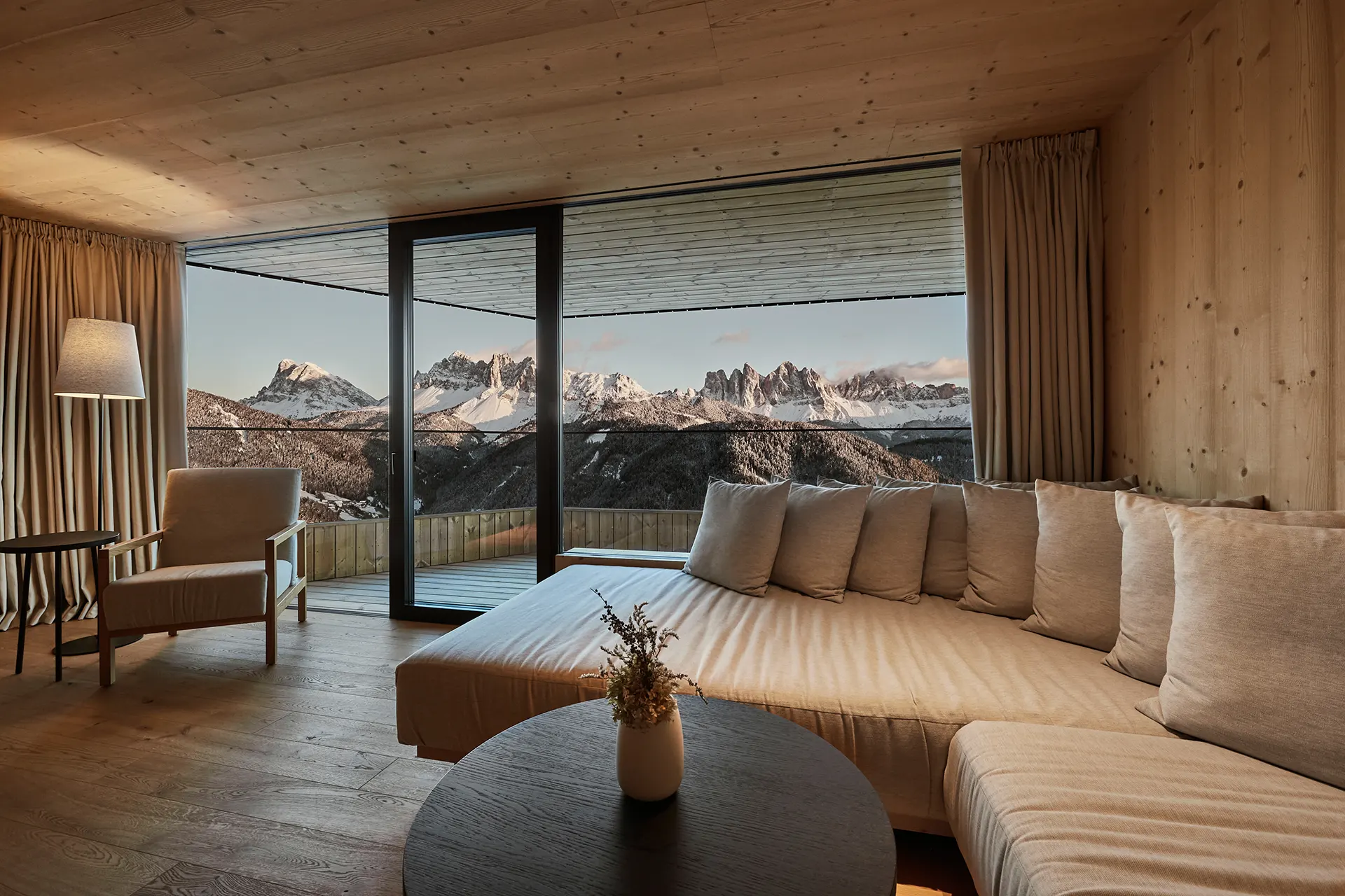 Wohnzimmer mit riesiger Fensterfront und Bergblick