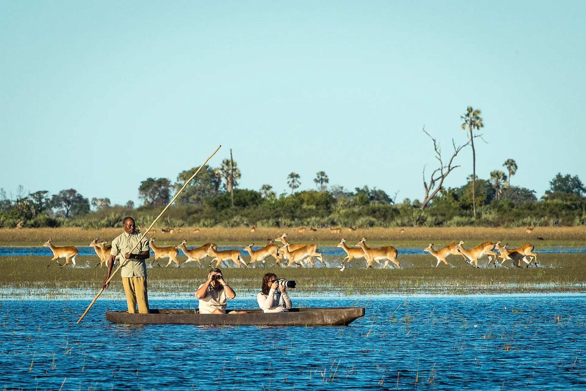 Drei Personen auf afrikanischem Holzboot