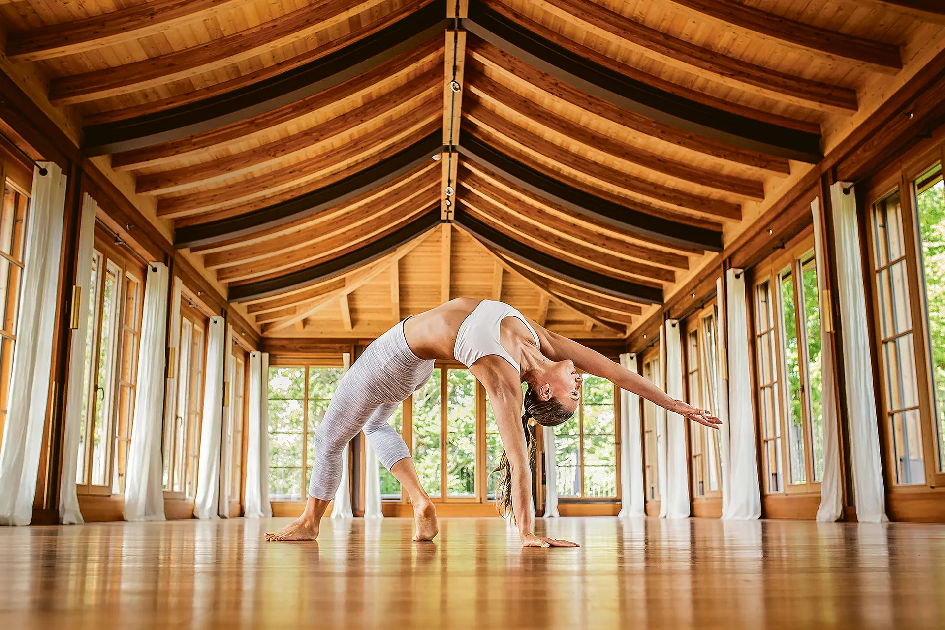 Frau macht Yoga Pose in großem Saal
