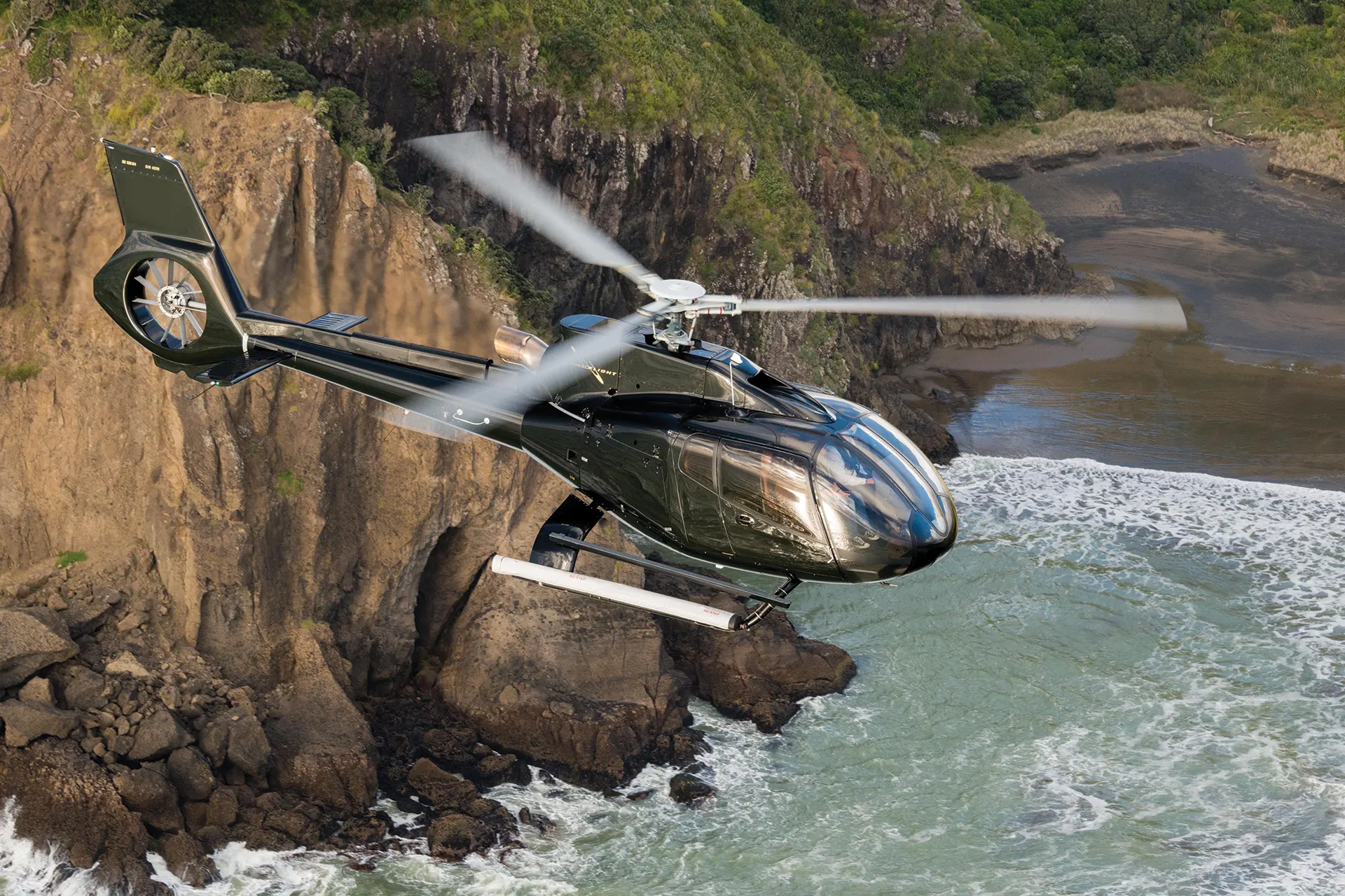 Helikopter fliegt über Meeresklippen