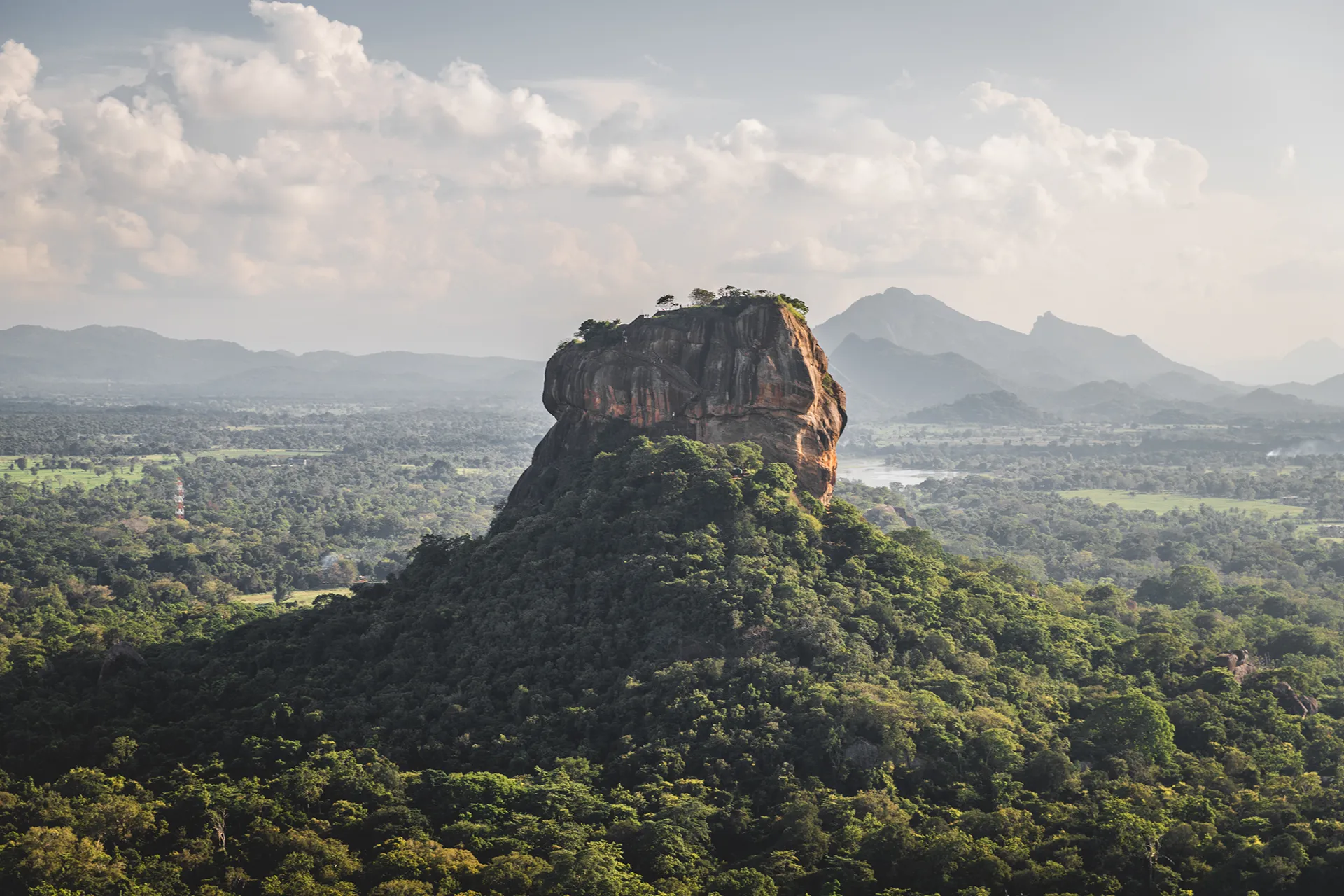 Sigiriya-Felsen vor üppiger Landschaft und Bergkulisse