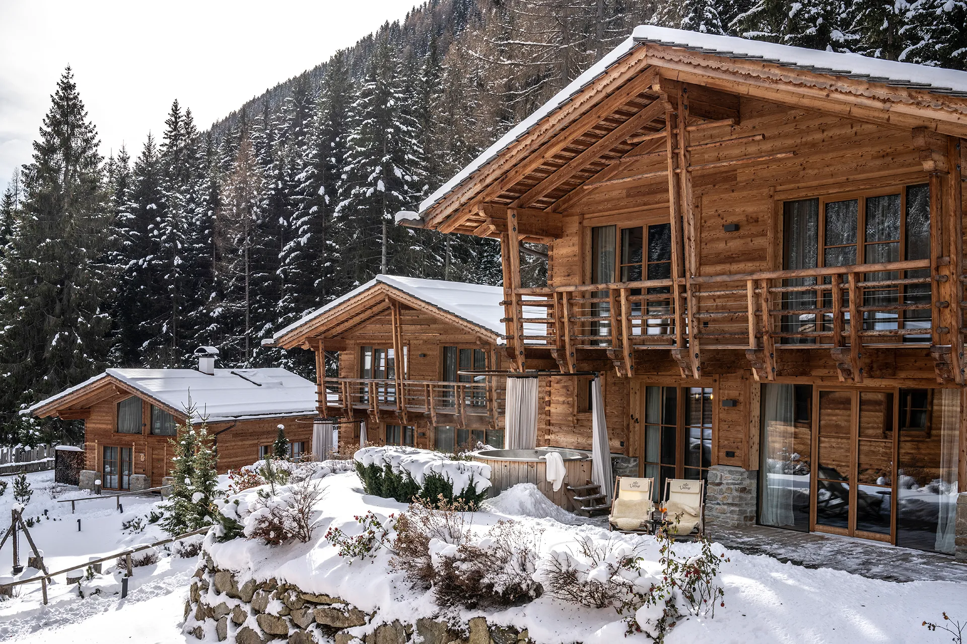 Drei Holzhäuser nebeneinander in Winterkulisse