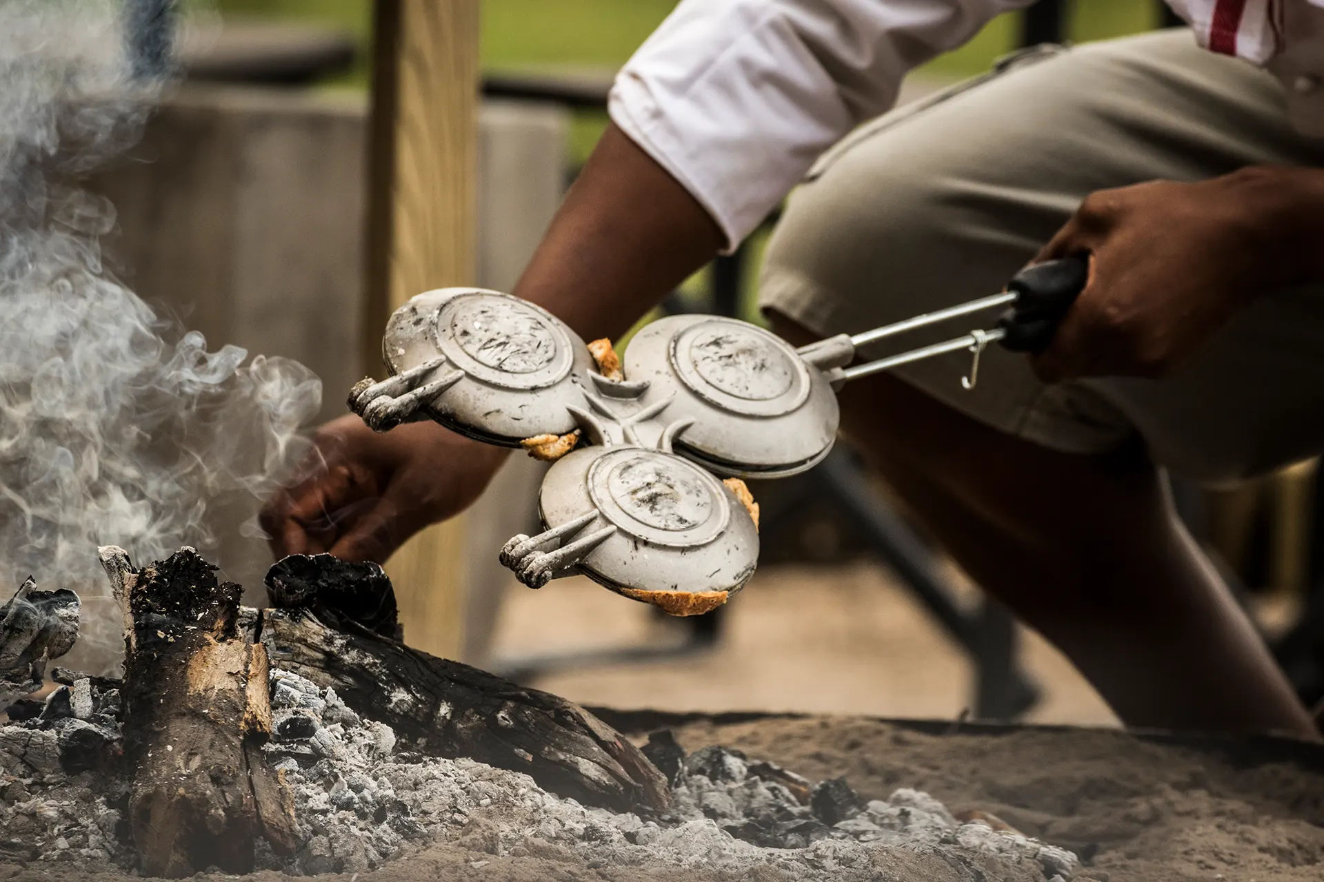 Traditionelles Waffeleisen wird ins Feuer gehalten